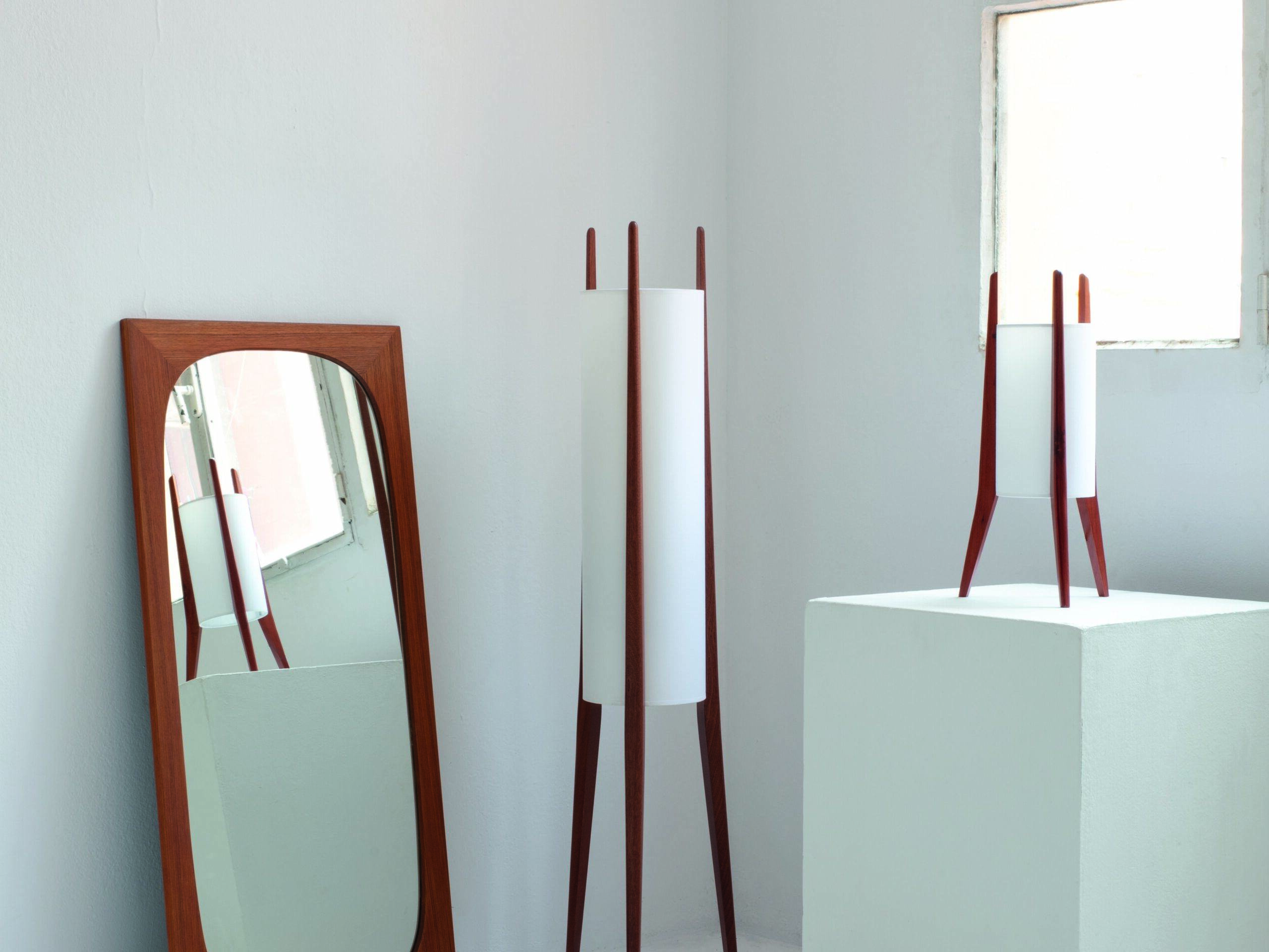 Lámpara de pide de diseño junto a espejo, iluminación elegante en interior luminoso